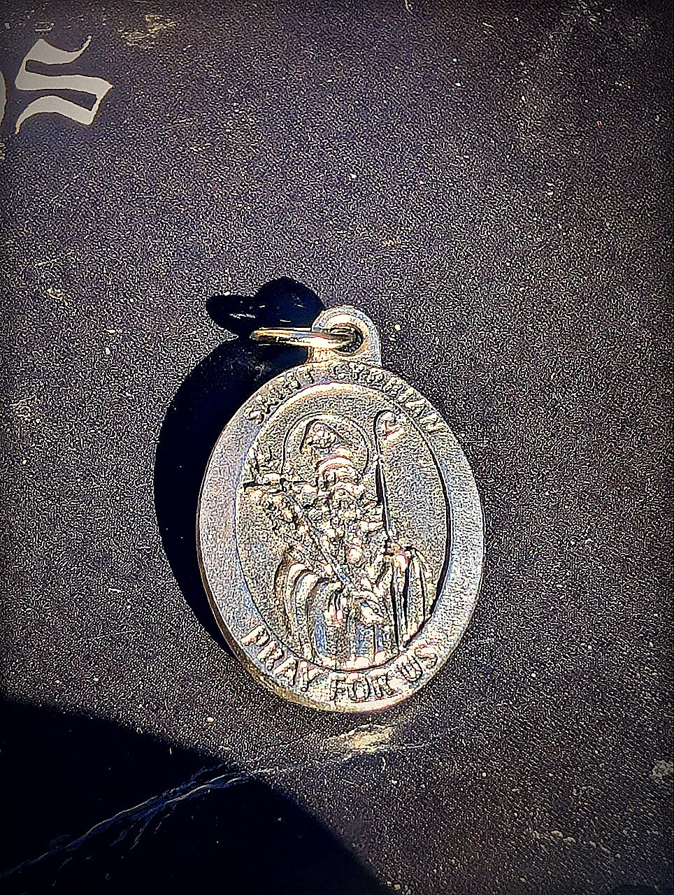 Saint Cyprian medal detail with mysterious black altar cloth