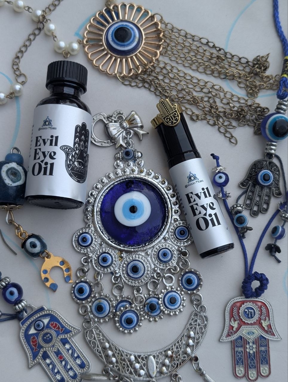 Evil Eye Oil bottle and roller surrounded by protective charms