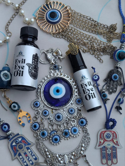 Evil Eye Oil bottle and roller surrounded by protective charms